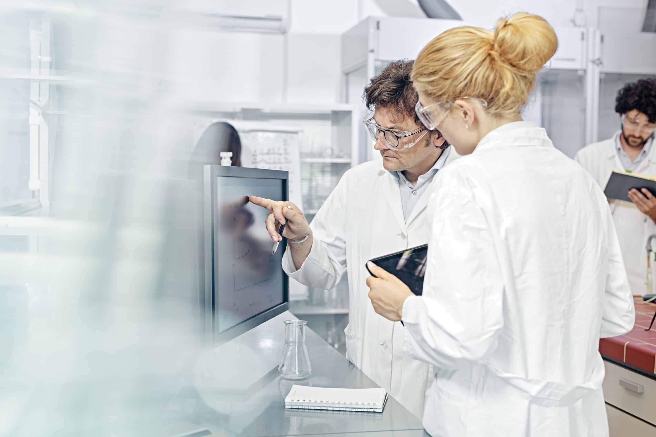 scientists analysing a graph in a lab