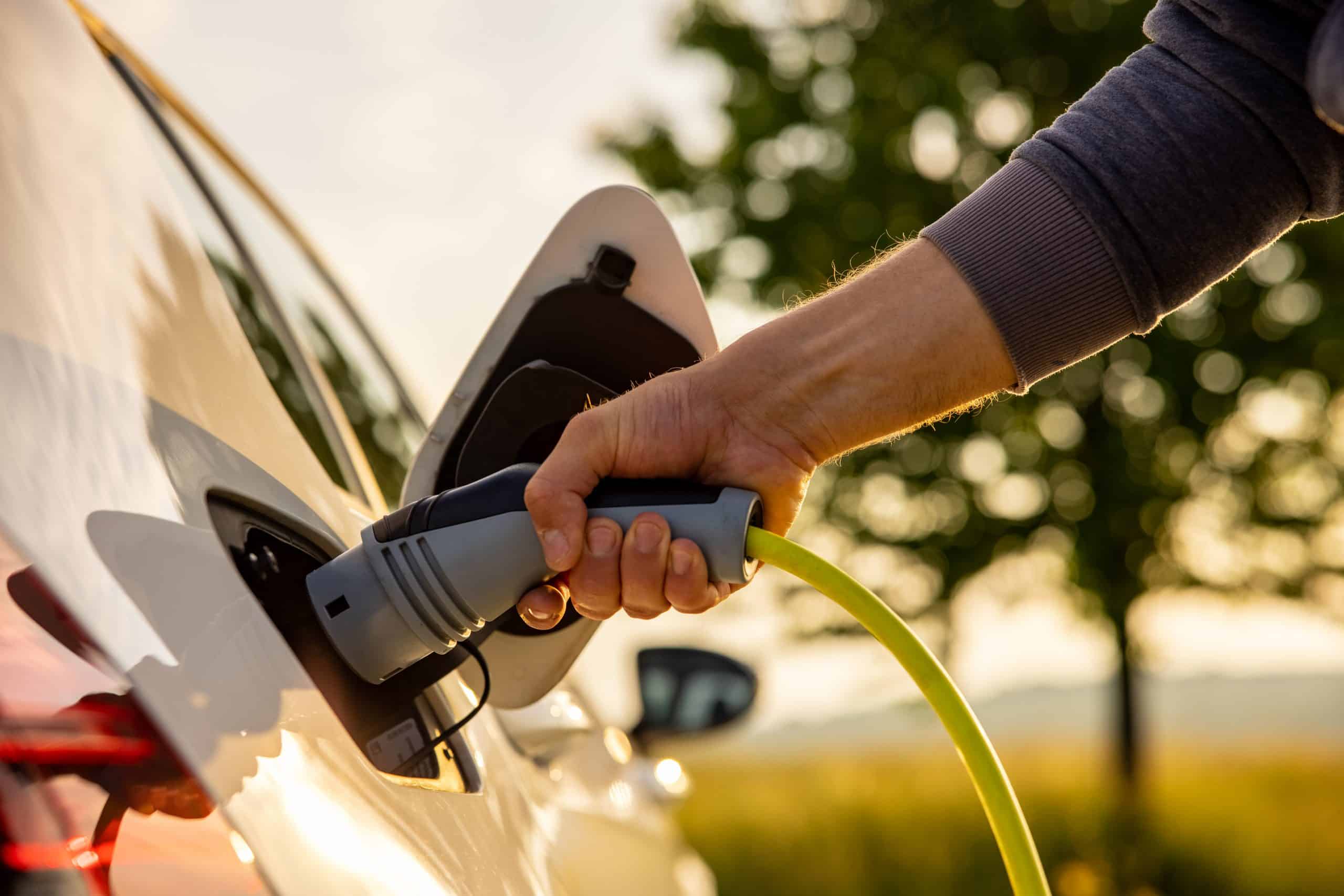 man recharging an electric car